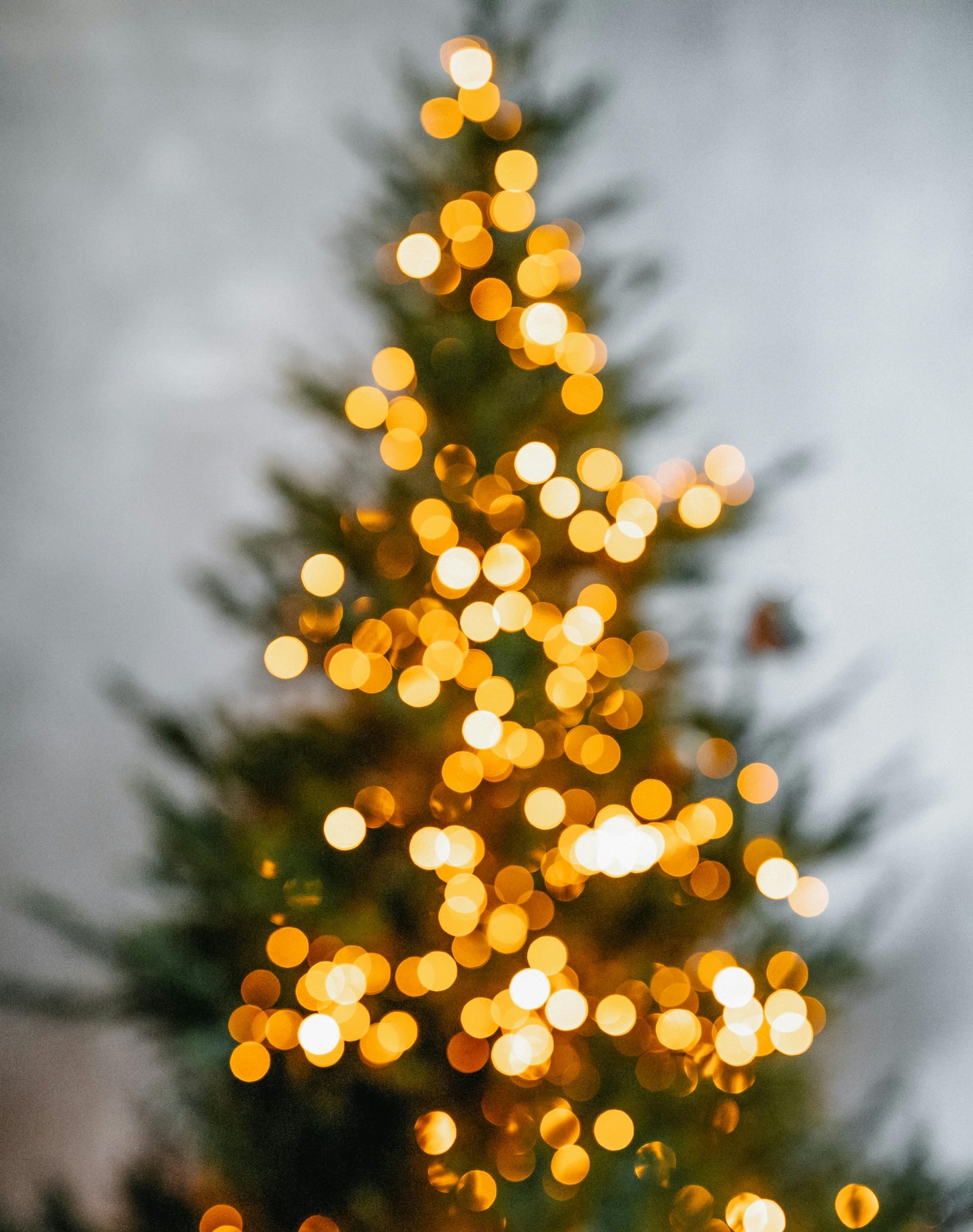Decorative Christmas tree with blurred lights against a gray background