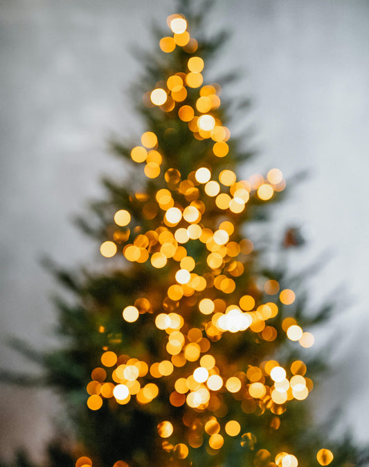 Decorative Christmas tree with blurred lights against a gray background